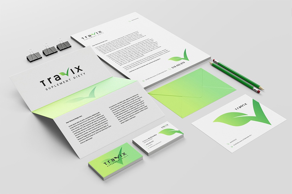 Zestaw materiałów brandingowych firmy Travix Suplement Diety: wizytówki z gradientem zieleni, papier firmowy, koperta, teczka i dwa ołówki na jasnoszarym tle.