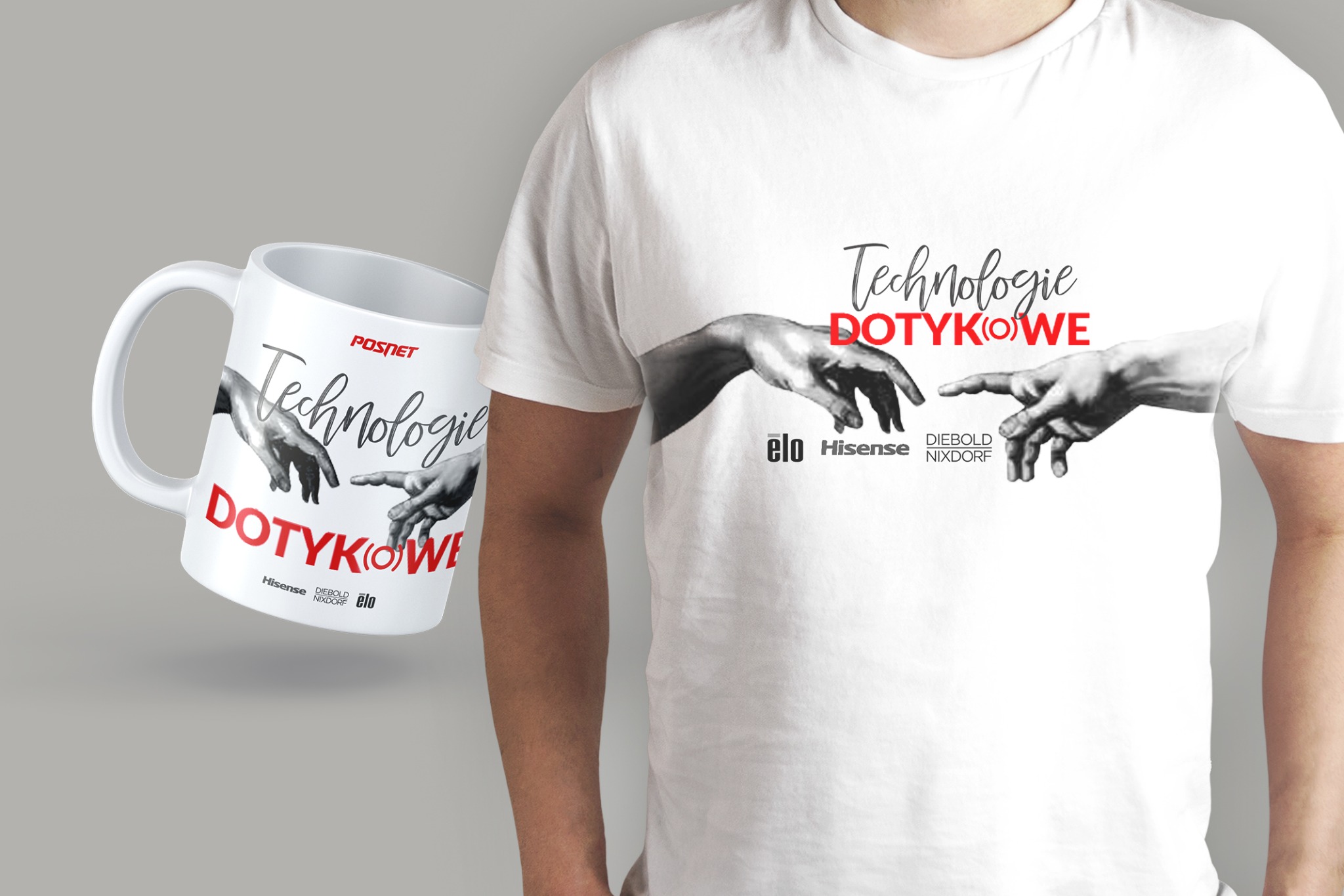 Mężczyzna w białej koszulce z nadrukiem dłoni i napisem 'Technologie Dotykowe' oraz kubek z tym samym nadrukiem, na szarym tle.