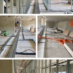 KRAFBAU - usługi budowlano-remontowe - Korytarz w trakcie montażu ścian działowych z metalowych profili. Widoczne kable i instalacje. Surowy stan wykończenia, przygotowanie do dalszych prac.
