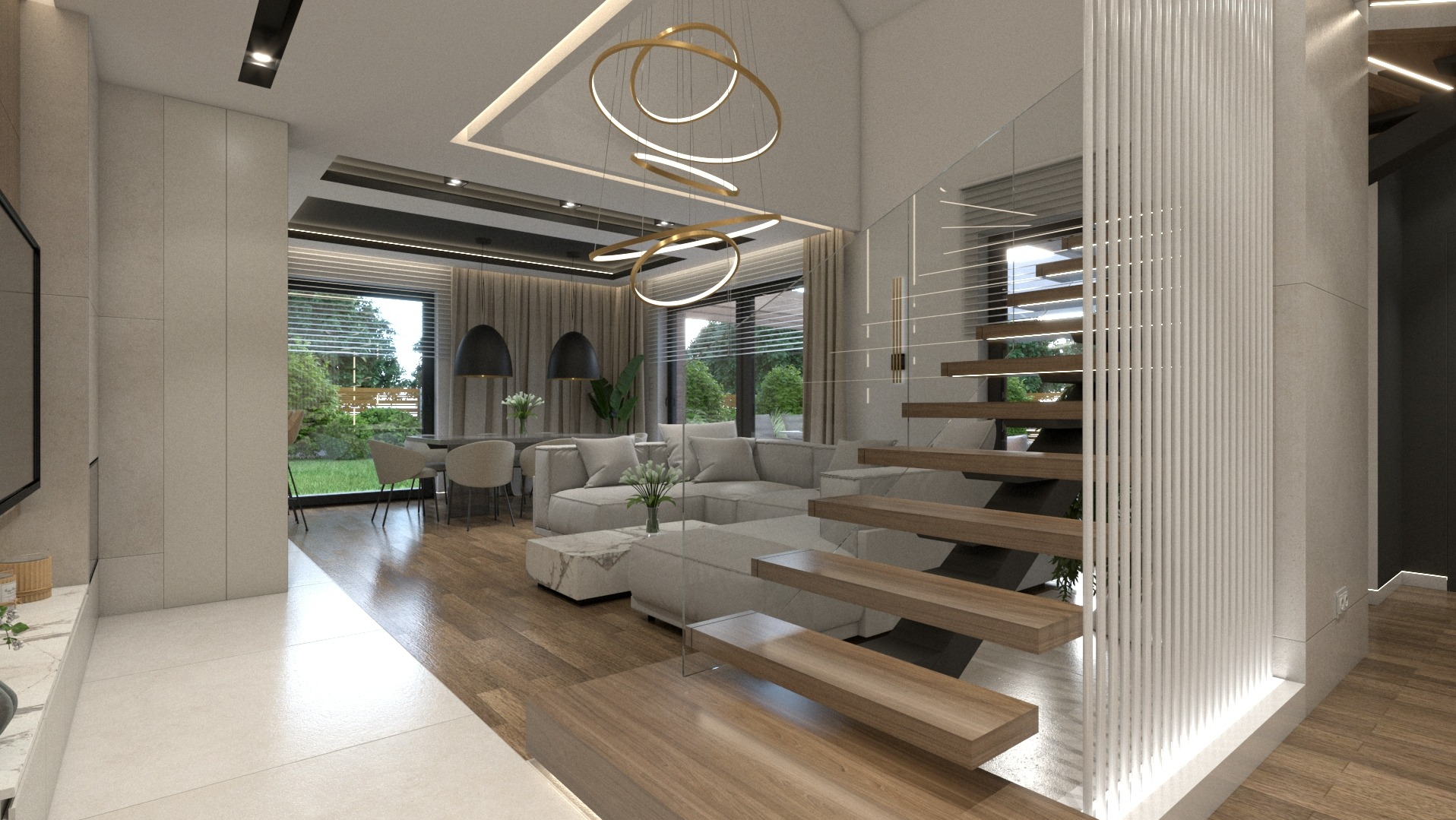 Jasne, przestronne wnętrze salonu z drewnianymi schodami, szarą sofą narożną i okrągłym, nowoczesnym żyrandolem. Widok na ogród przez duże okna.