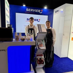 Eventship Weronika Pietruszka - Stoisko firmowe na targach z dwójką osób w fartuchach, ekspres do kawy, materiały informacyjne i logo firmy w tle.