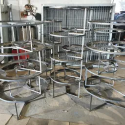 Szkielety metalowych stolików z okrągłymi blatami, wykonane przez ślusarza z Rogozina, oczekujące na dalszą obróbkę w warsztacie.