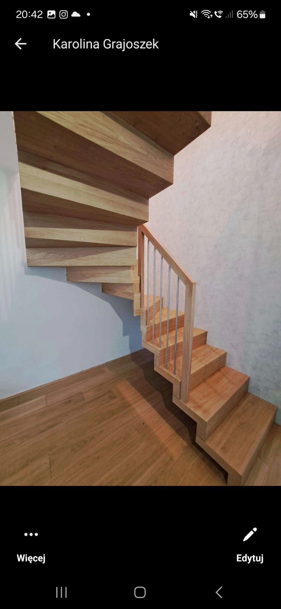 Kaskadowe schody drewniane z metalowymi poręczami, widoczne z dołu, z drewnianą podłogą w tle.