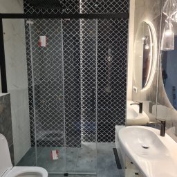 Jacek - Nowoczesna łazienka z kabiną prysznicową typu walk-in, umywalką nablatową z czarną armaturą, lustrem z podświetleniem LED i dekoracyjnymi płytkami w geometryczny wzór.