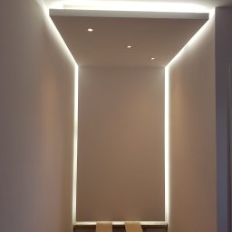 Jacek - Wnęka z oświetleniem LED na suficie i ścianach, widoczne trzy punktowe lampy, zabezpieczona podłoga przed zabrudzeniem podczas prac wykończeniowych.