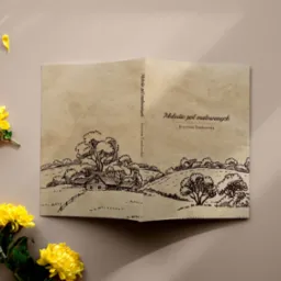 Otwarta książka z ilustracją krajobrazu wiejskiego w stylu retro, leżąca na beżowym tle z żółtymi kwiatami chryzantemy po lewej stronie.