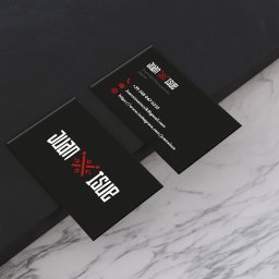 Varietatis - Dwie czarne wizytówki leżące pod kątem na marmurowym i czarnym tle. Wizytówki z białym napisem 'Juan X Isue' i czerwonym elementem graficznym, zawierają dane kontaktowe: numer telefonu, adres email...