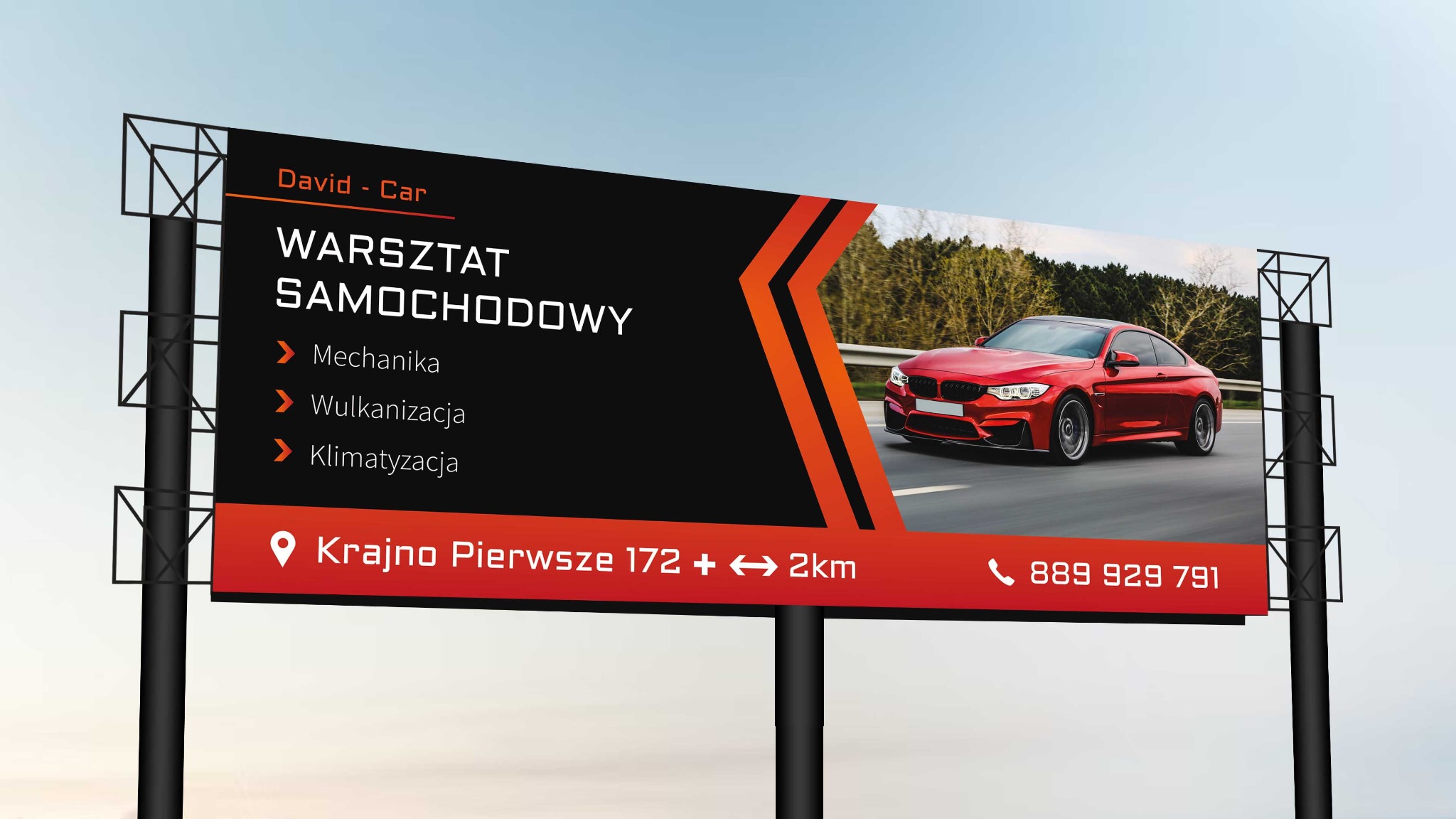 Billboard reklamowy warsztatu samochodowego David-Car z czerwonym sportowym samochodem, oferującego mechanikę, wulkanizację i klimatyzację, zlokalizowanego w Krajnie Pierwszym.