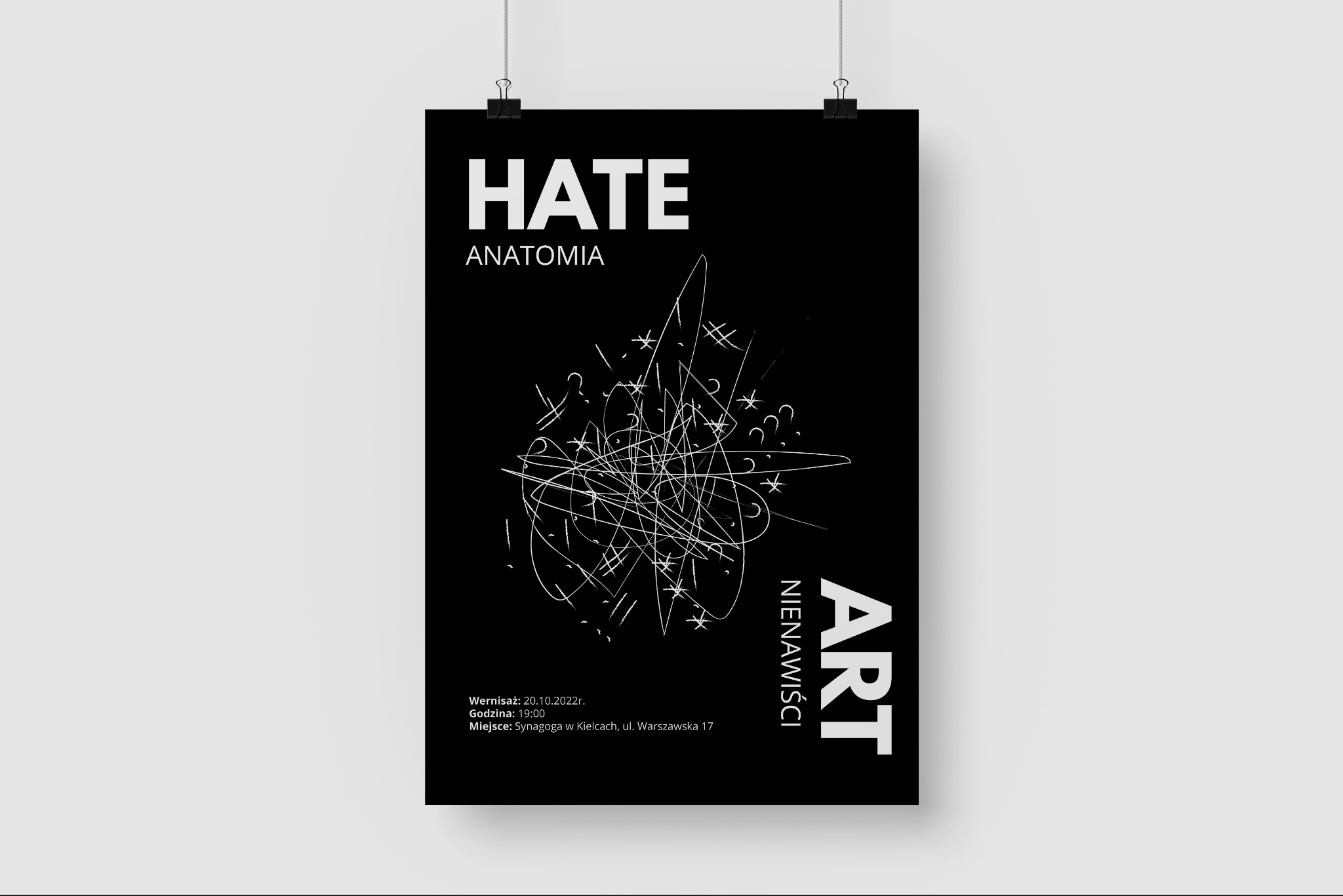 Plakat z czarnym tłem, białym napisem 'HATE ANATOMIA' i abstrakcyjnym rysunkiem przypominającym białe linie, pytajniki i gwiazdki, wiszący na dwóch klipsach