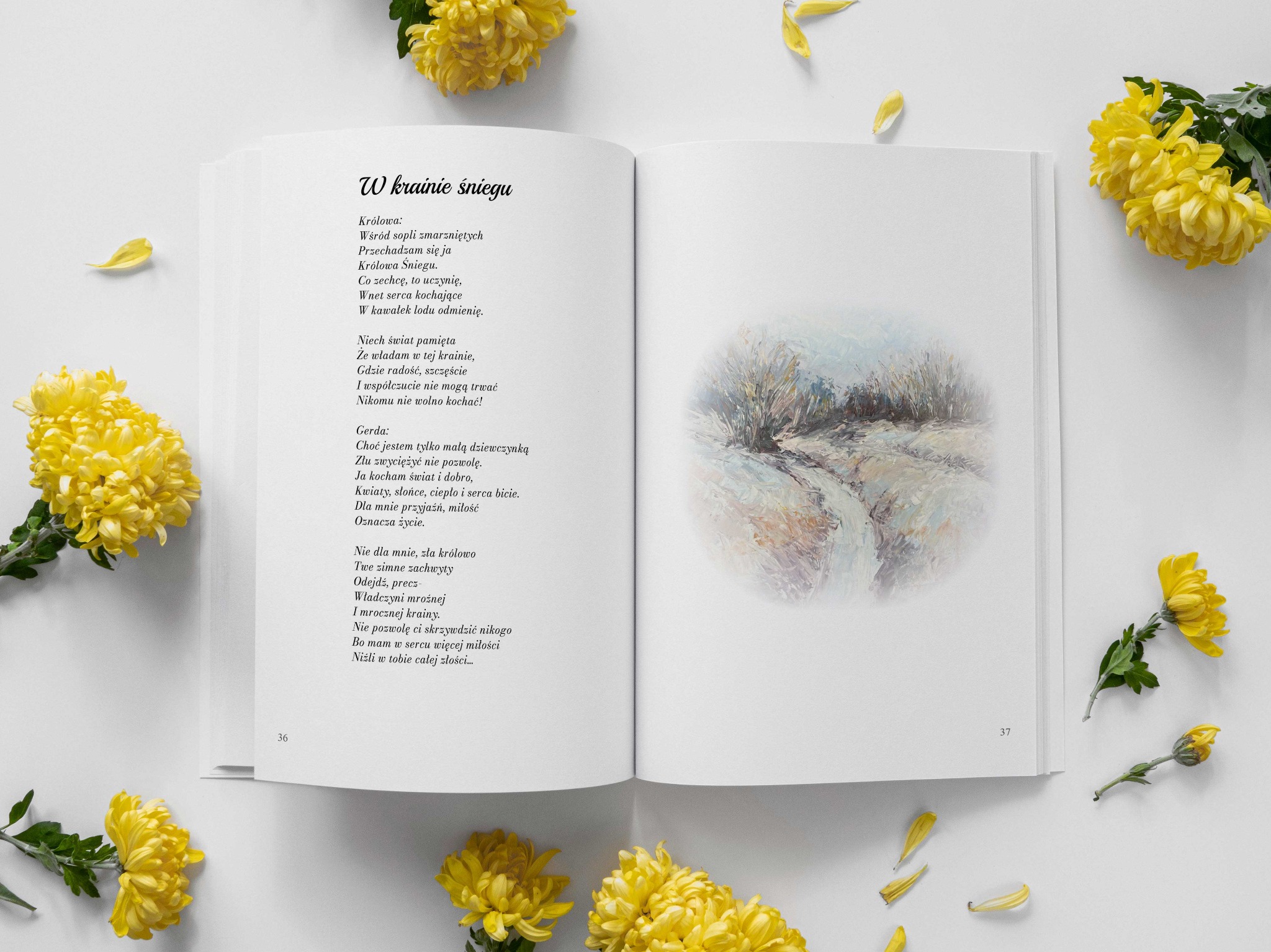 Otwarta książka z wierszem 'W krainie śniegu', obok której leżą żółte chryzantemy i płatki kwiatów, na białym tle.