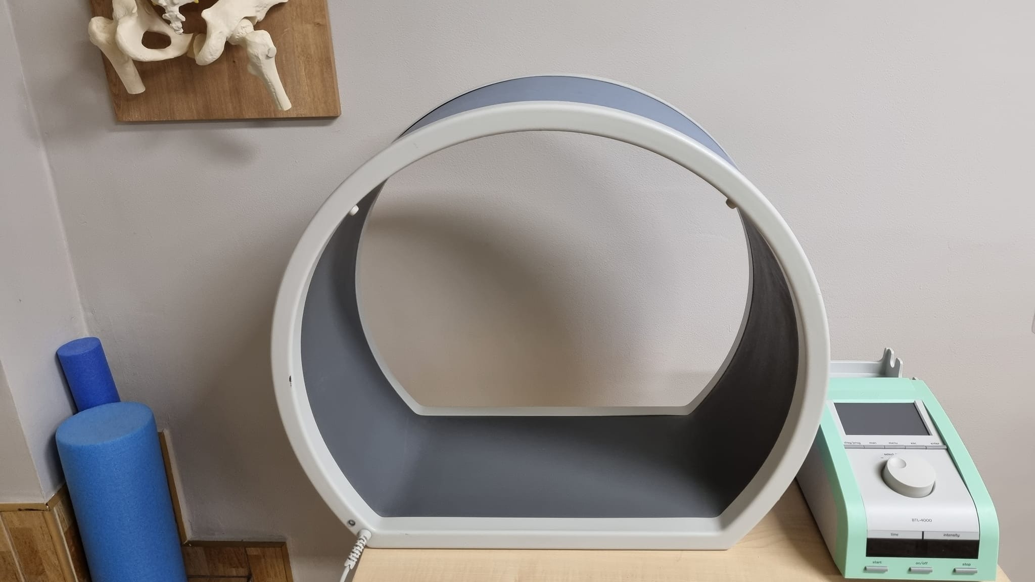 Aparat do magnetoterapii BTL-4000 z widocznym panelem sterowania i modelem miednicy na ścianie w tle.