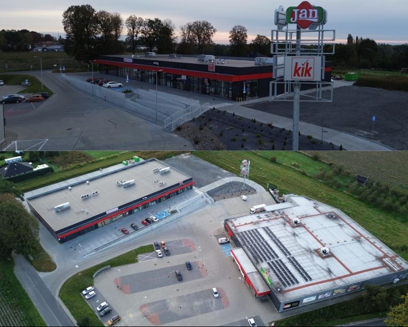 Kompleks handlowy z lotu ptaka, widoczne parkingi, sklepy Jan i Kik. Ujęcie z góry ukazuje rozległy teren i architekturę budynków w jesiennej scenerii.