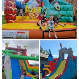 Mobil Event Patryk Wojda - Kolorowe dmuchańce z motywami zwierzęcymi na trawie, bawiące się dzieci z podniesionymi rękami, na tle ceglanego budynku.