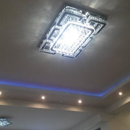 Krystian Gula - Sufit podwieszany z oświetleniem LED w kolorze niebieskim i zielonym oraz dwa ozdobne żyrandole kryształowe.