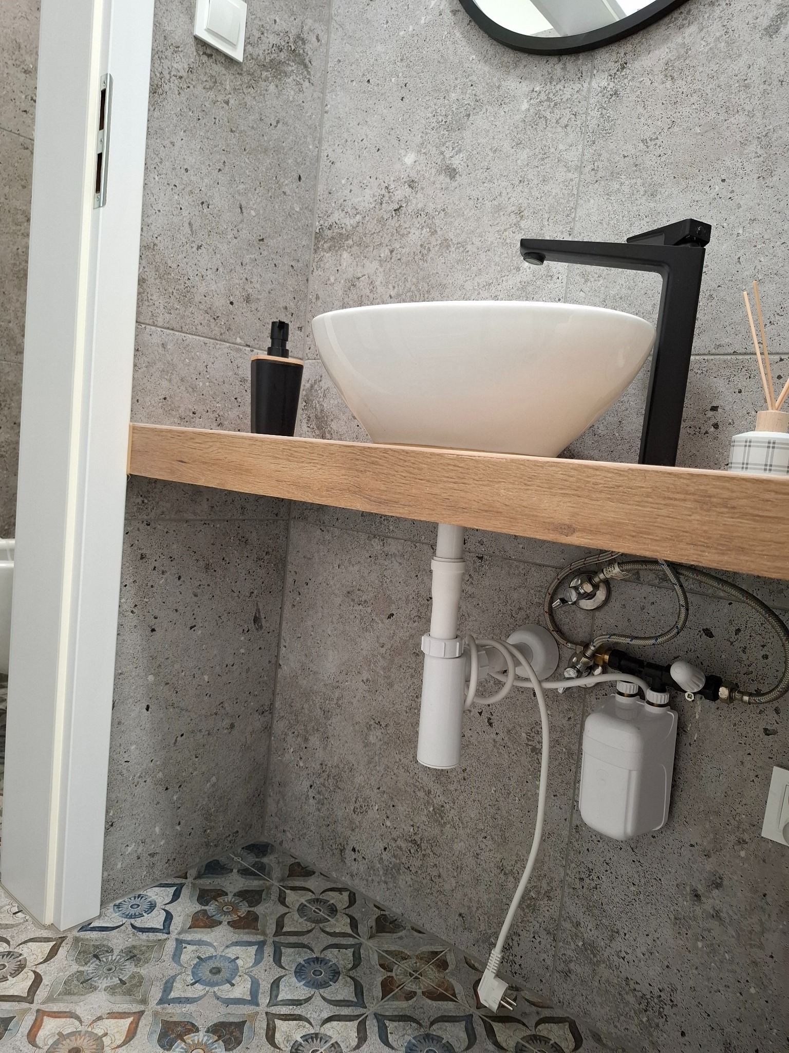 Umywalka z przepływowym podgrzewaczem wody.