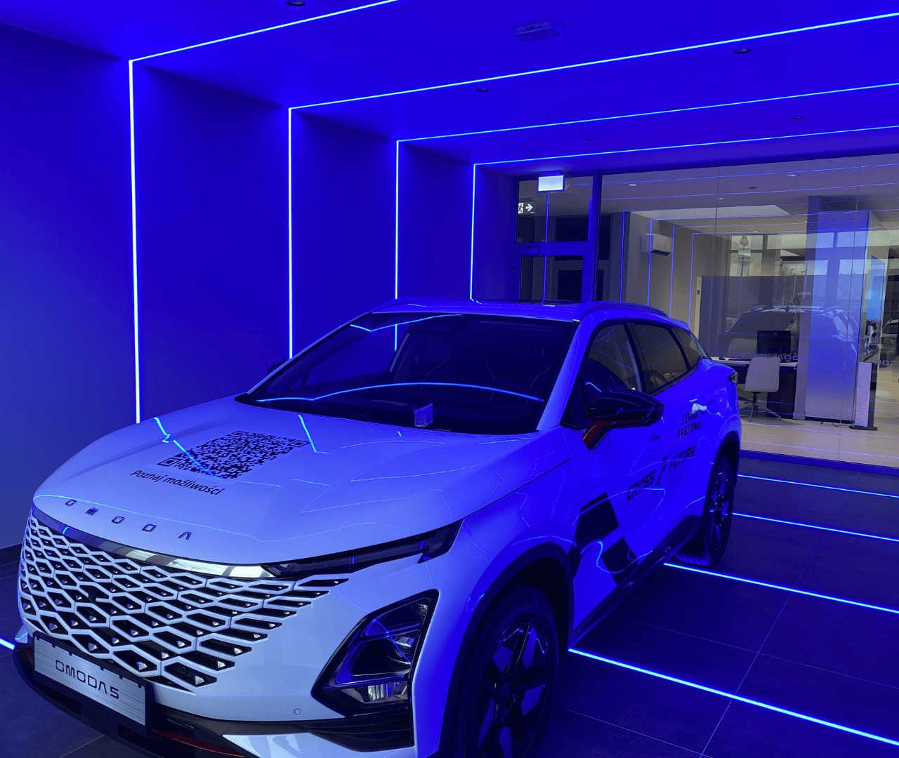 Prezentacja OMODA – efektowna iluminacja LED podkreślająca nowoczesny charakter salonu.