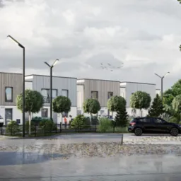 Wizualizacja osiedla domów jednorodzinnych z drewnianą elewacją, widok z poziomu ulicy, samochody zaparkowane na podjeździe, jesienne liście na kostce brukowej, nowoczesne lampy oświetleniowe.