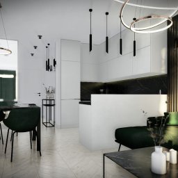 Sebastian Filuś - Wizualizacja wnętrza: jadalnia z zielonymi krzesłami i marmurowym stołem, otwarta na kuchnię z czarnym blatem i białą zabudową, oświetlona nowoczesnymi lampami wiszącymi.