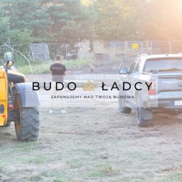 Budowładcy sp. z o.o. - Żółta ładowarka teleskopowa i szary pickup Ford Ranger na placu budowy z widocznymi zbrojeniami fundamentów w tle, osoba w koszulce z logo firmy budowlanej stoi obok.