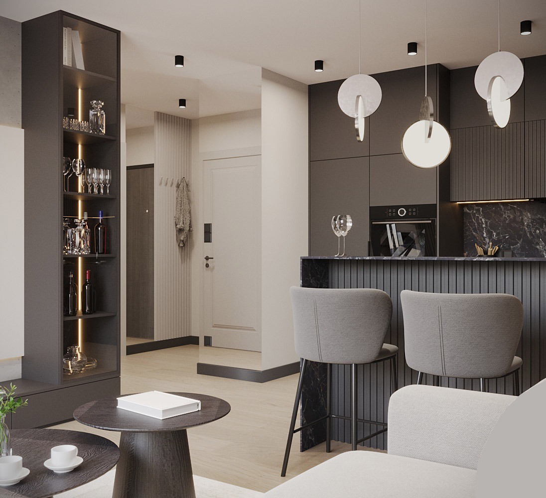 Nowoczesne wnętrze mieszkania z otwartą kuchnią, szarymi meblami i wyspą, oświetlone wiszącymi lampami o okrągłych kloszach, z widocznym regałem na alkohol i dekoracje.