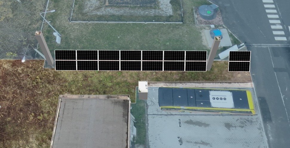 Widok z góry na panele słoneczne zamontowane wzdłuż krawędzi dachu budynku, obok przystanku autobusowego z żółtym autobusem.