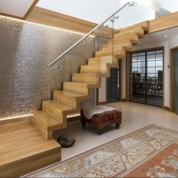 Schody dywanowe wolnostojące z szybami oraz poręczą ze stali nierdzewnej 