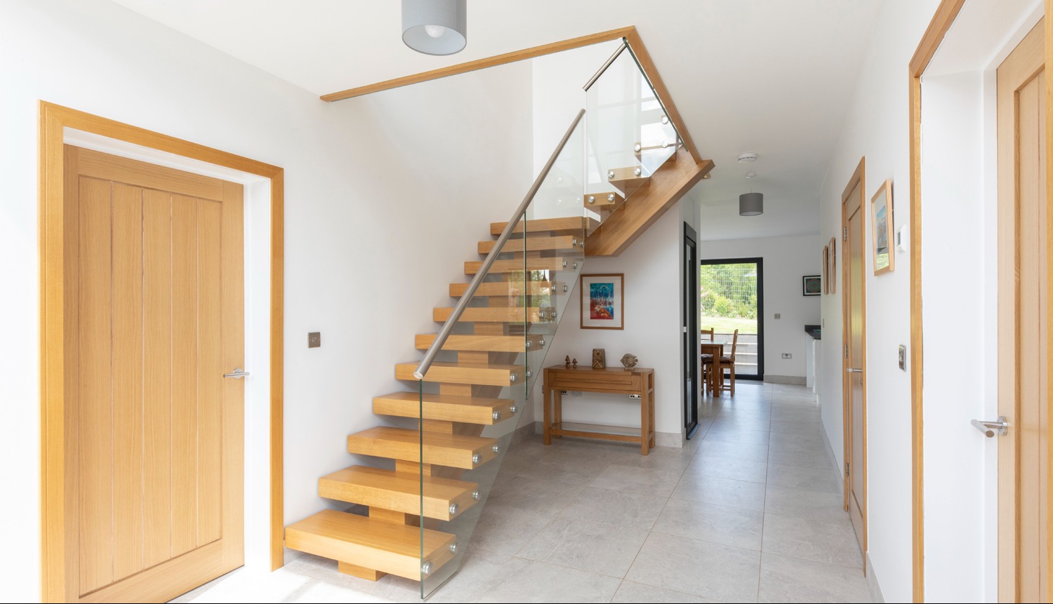 Schody dębowe na policzku centralnym z szybami oraz poręczą ze stali nierdzewnej