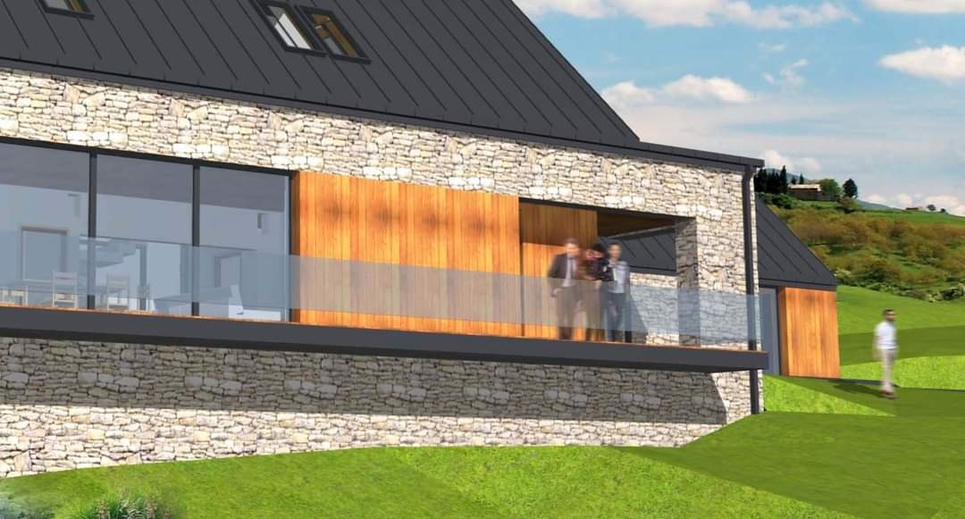 Wizualizacja domu z elewacją z kamienia i drewnianymi panelami, balkon z szklaną balustradą, dach dwuspadowy z oknami dachowymi, w tle pagórkowaty krajobraz.