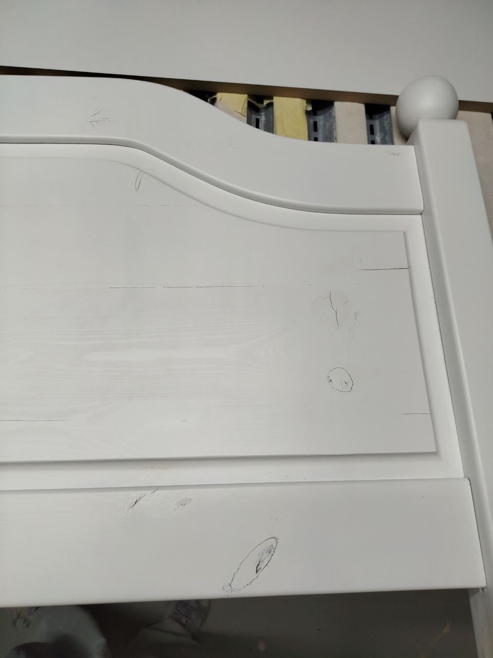 Fragment białej, niedokończonej szafki z drewna, z widocznymi niedoskonałościami i śladami po ołówku, prawdopodobnie w trakcie renowacji w Tczewie.