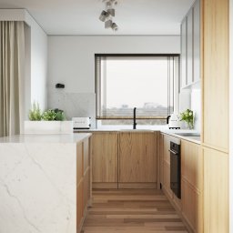 Moye Concept - Jasna kuchnia z drewnianymi frontami, marmurowym blatem wyspy i sprzętem AGD marki Smeg, oświetlona reflektorami sufitowymi.