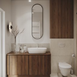 Moye Concept - Nowoczesna łazienka z drewnianą szafką pod umywalką nablatową, owalnym lustrem w czarnej ramie i minimalistyczną toaletą podwieszaną.