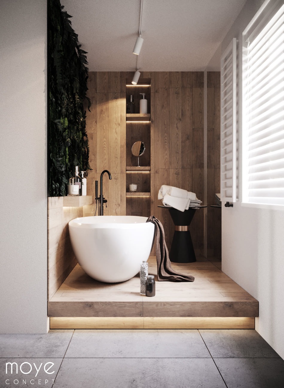 Nowoczesna łazienka z wolnostojącą białą wanną na drewnianym podeście z podświetleniem LED, drewniane panele na ścianie, pionowy ogród z roślin, czarna armatura i dekoracje.