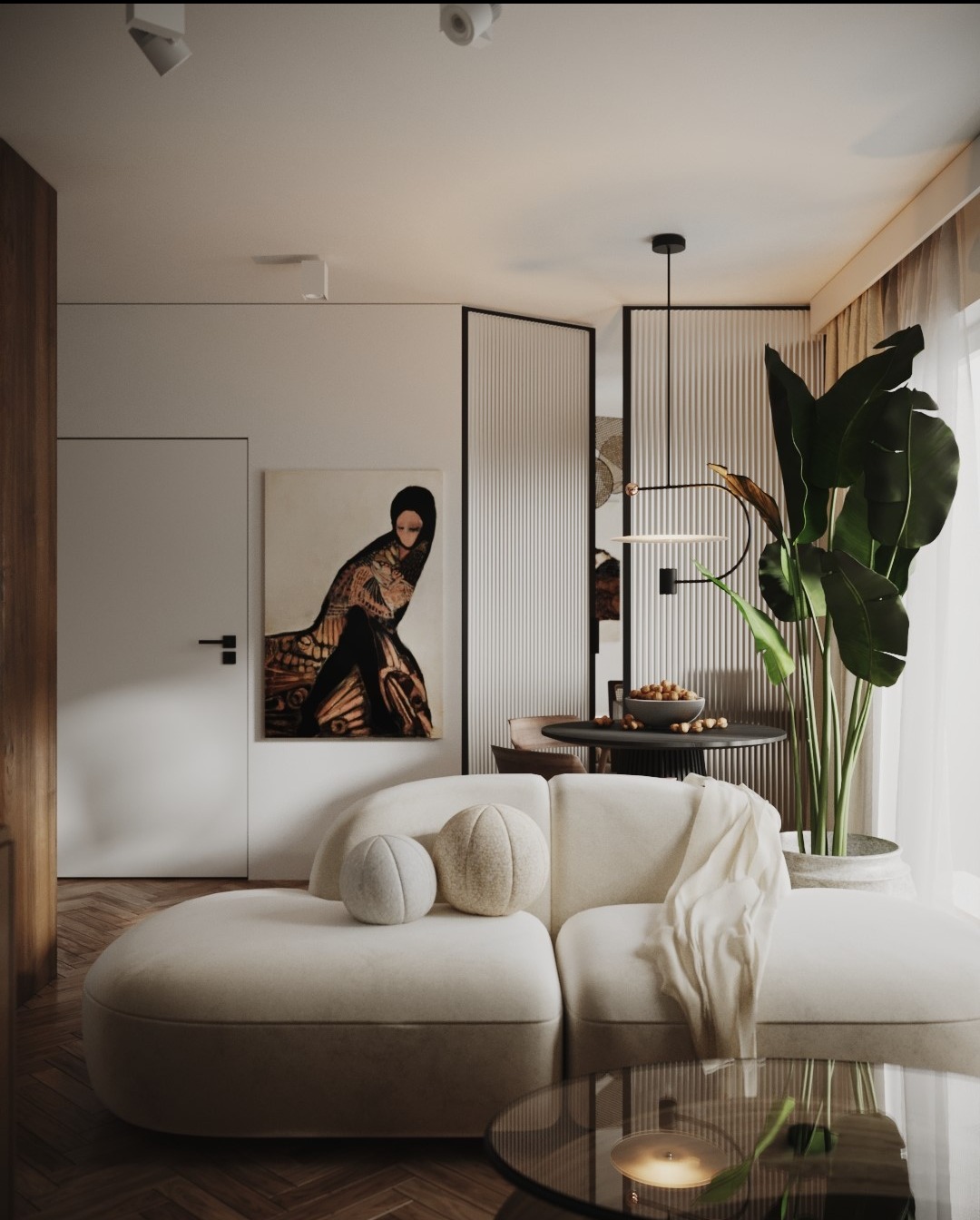 Jasne, przestronne wnętrze salonu z kremową sofą modułową, okrągłym stolikiem kawowym z brązowego szkła, obrazem kobiety w orientalnym stroju na ścianie i wysoką rośliną doniczkową przy oknie.