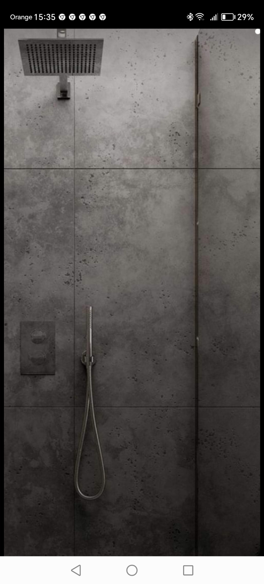 Nowoczesna kabina prysznicowa z deszczownicą i szarą, betonową okładziną ścienną.