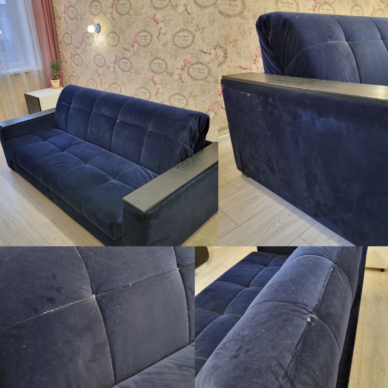 Granatowa, welurowa sofa z drewnianymi podłokietnikami w pokoju z wzorzystą tapetą. Widoczne drobne zabrudzenia na tapicerce.