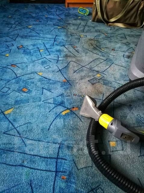 Czyszczenie wzorzystego, niebieskiego dywanu za pomocą odkurzacza piorącego z żółtą końcówką, widoczne ślady po czyszczeniu.