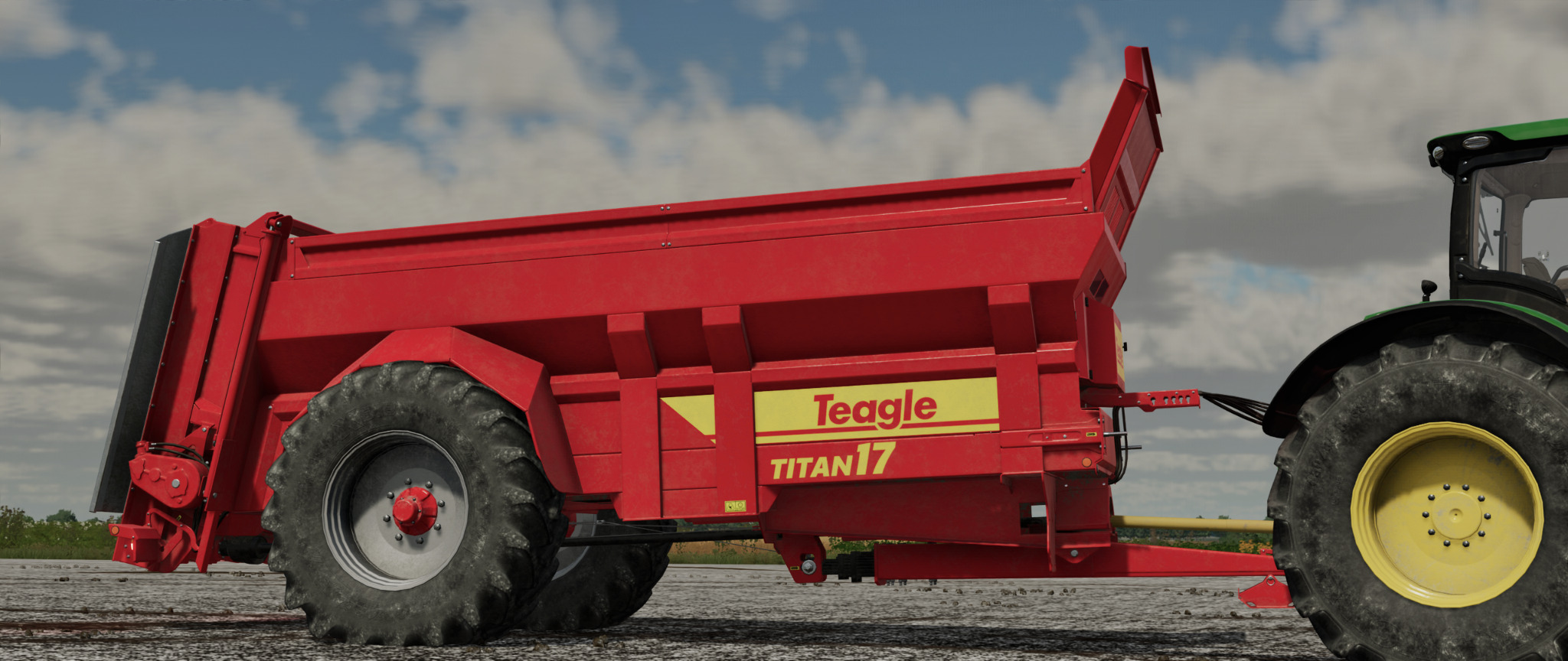 Czerwona przyczepa rolnicza Teagle Titan 17 podłączona do zielonego traktora na tle pochmurnego nieba.