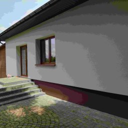 SOLID Adam Adamus - Świeżo otynkowana elewacja domu jednorodzinnego z brązowymi oknami i drzwiami. Widoczne schody wejściowe z kostki brukowej i wiadro z farbą.