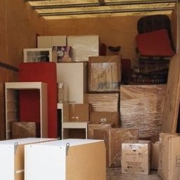 F.U.H SHOW - Wnętrze przestrzeni ładunkowej wypełnione meblami i kartonami, przygotowanymi do transportu, zabezpieczonymi folią stretch.