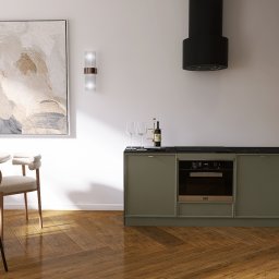 Pracownia Przedpokój Joanna Gołos - Nowoczesna kuchnia z oliwkowymi szafkami, czarnym blatem i drewnianymi akcentami, uzupełniona okrągłym stołem z krzesłami w stylu retro i abstrakcyjnym obrazem na ścianie.