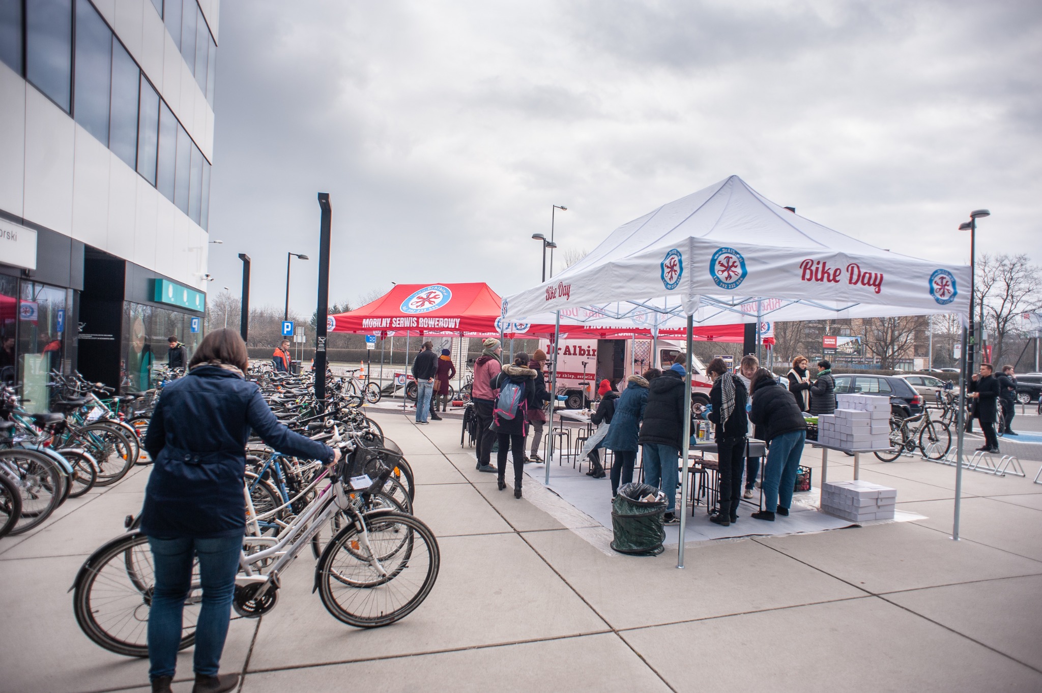 Mobilny serwis rowerowy podczas wydarzenia plenerowego Bike Day; widoczne rowery, stanowisko serwisowe pod namiotem, osoby oczekujące na naprawę.