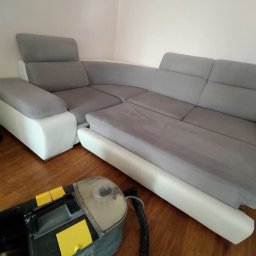 Przedsiębiorstwo Usługowe Paulina Gliszczyńska - Szaro-biały narożnik po praniu, widoczny odkurzacz piorący na drewnianej podłodze. W tle zegar na ścianie.