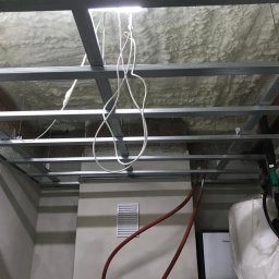 MAL-BUD - Montaż sufitu podwieszanego z izolacją piankową w Kuźnicy, widoczne profile metalowe i instalacje.