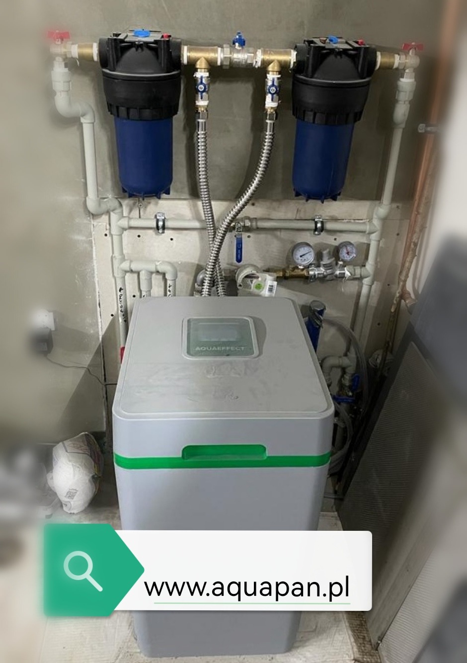 System filtrów wody Aquaeffect z dwoma pionowymi filtrami wstępnymi, manometrami i rurami zamontowany na ścianie w pomieszczeniu technicznym.