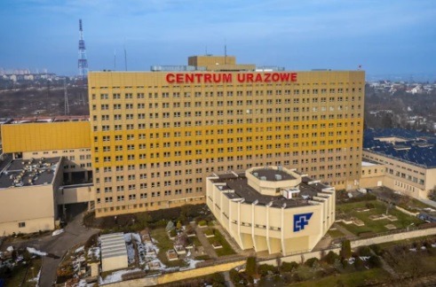 Wysoki budynek Centrum Urazowego z anteną w tle, widziany z góry, z elementami instalacji odgromowej na dachu i anteną na dachu budynku.