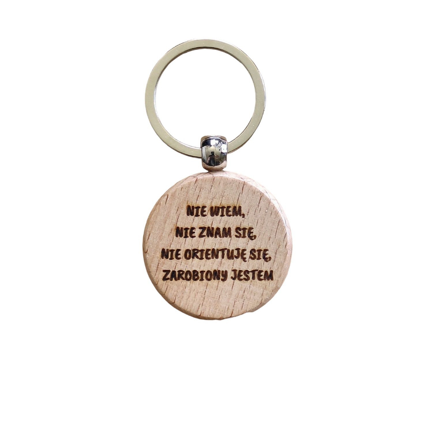 Drewniany brelok z wygrawerowanym napisem 'Nie wiem, nie znam się, nie orientuję się, zarobiony jestem'.