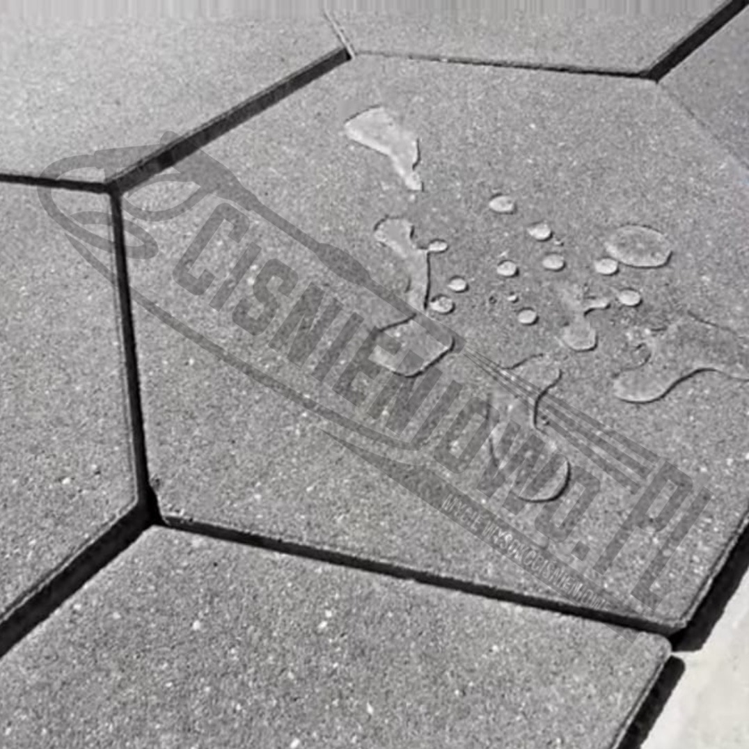 Szare, sześciokątne płyty chodnikowe z widocznymi kroplami wody na powierzchni. Na płytach widoczny znak wodny.