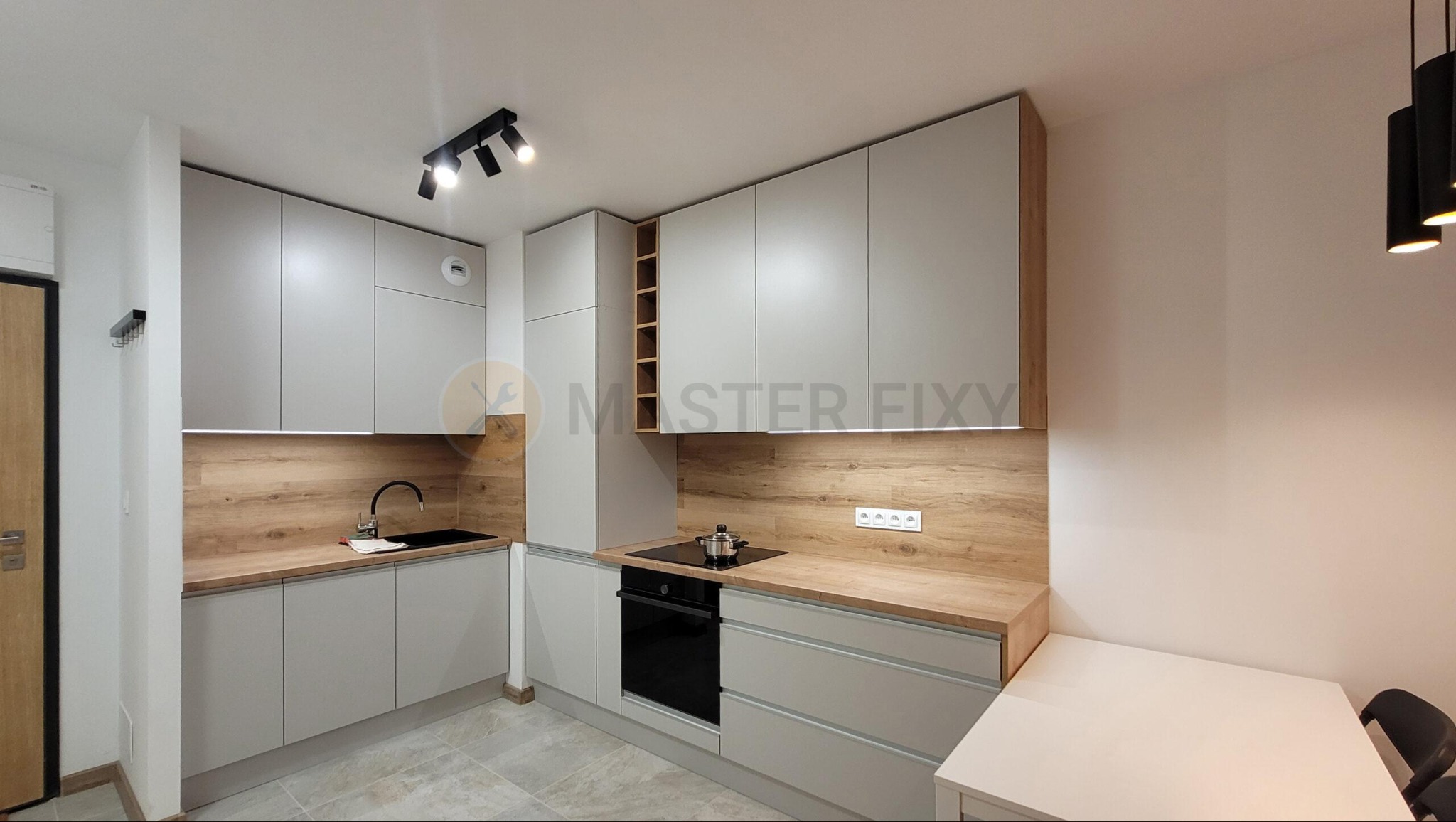 Kuchnia w szarym kolorze z drewnianym blatem i fartuchem, szara płytka