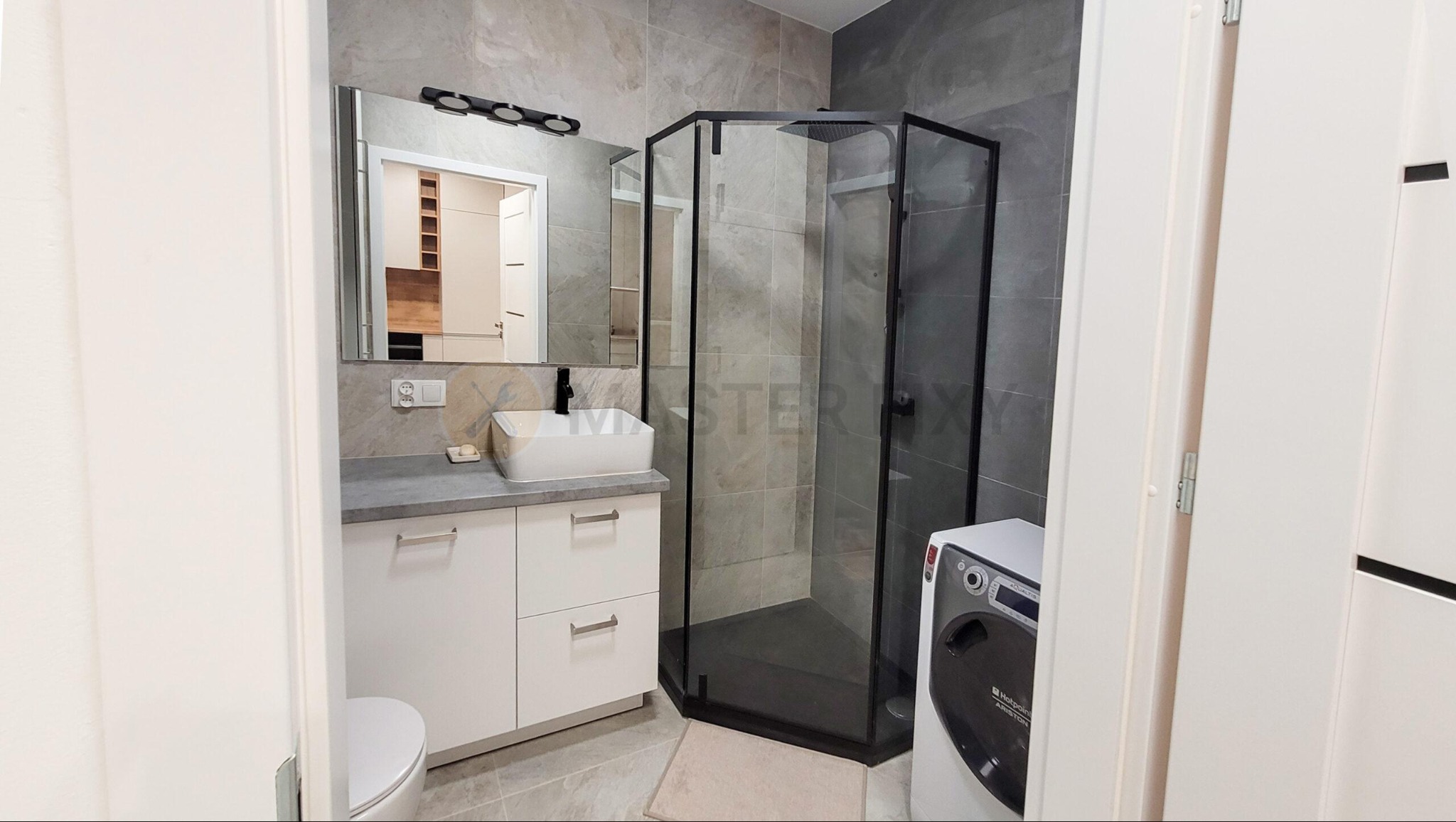 Łazienka po remoncie z funkcjonalnymi meblami i przestronną kabiną prysznicową