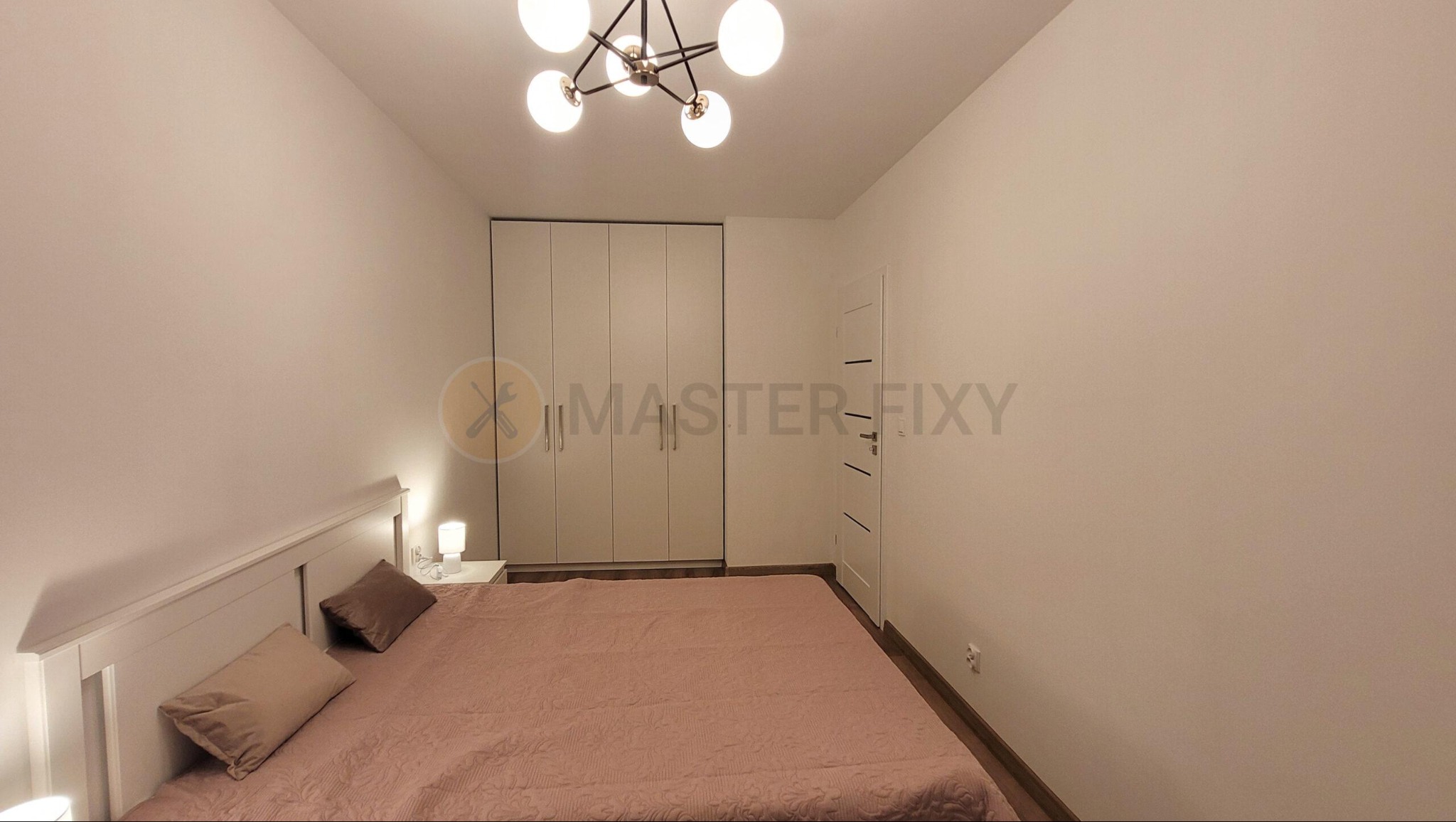 Sypialnia z łóżkiem i wbudowaną szafą na całą niszę